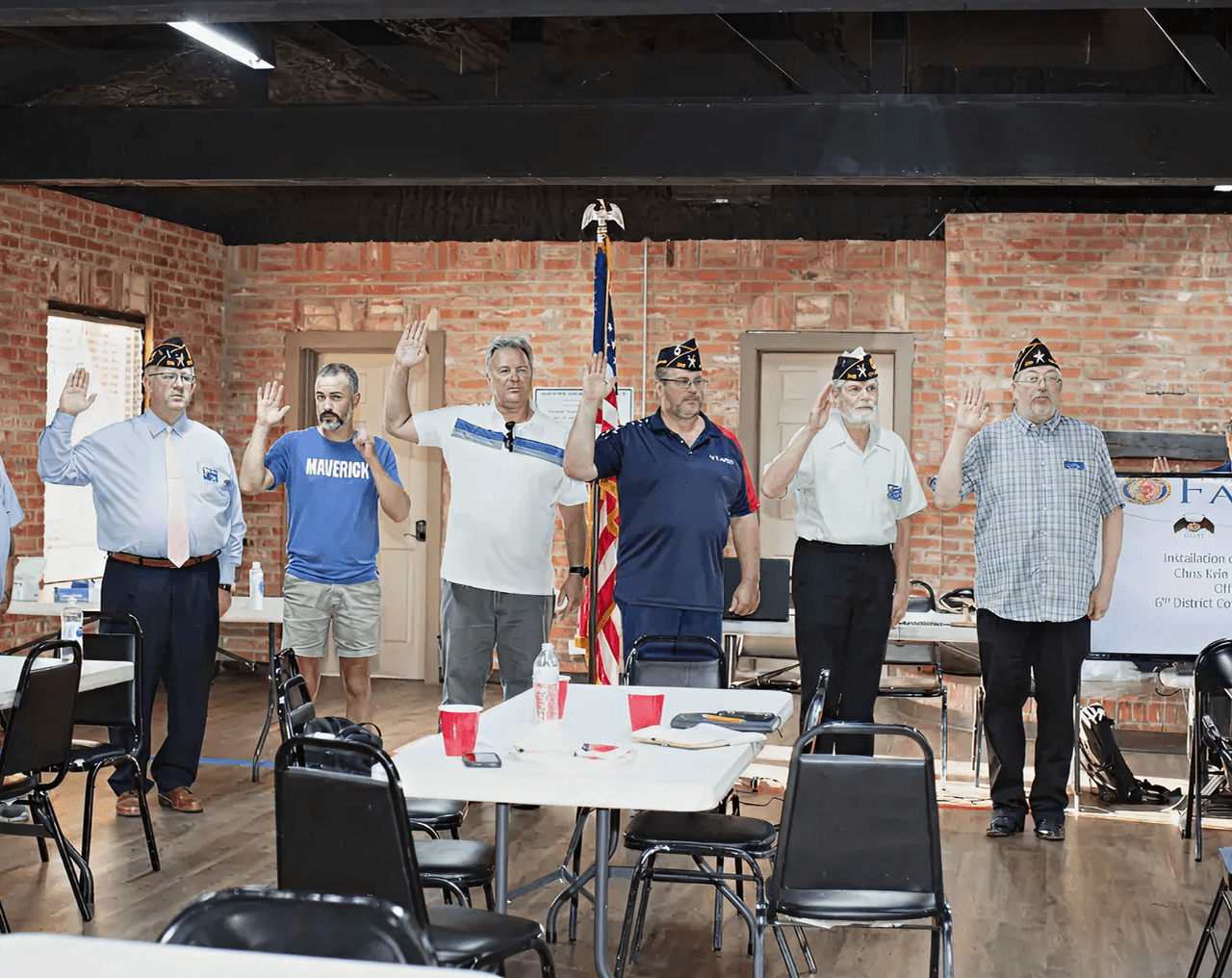 People standing indoors with hands raised.