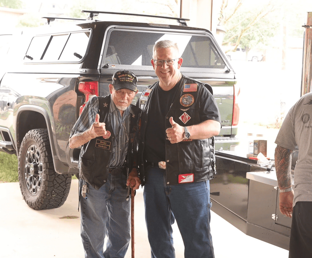 Two men smiling and giving thumbs up.